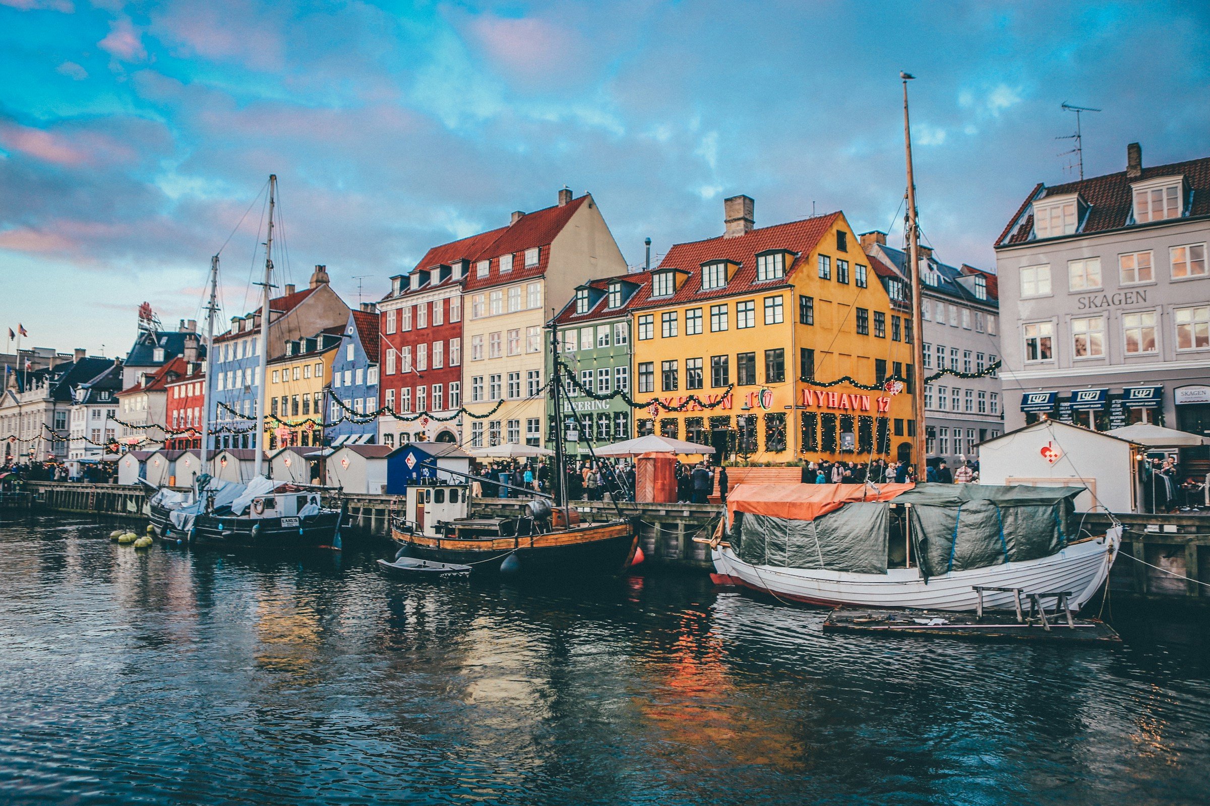 Båter i Nyhavn i København med fargerike bygninger i bakgrunnen