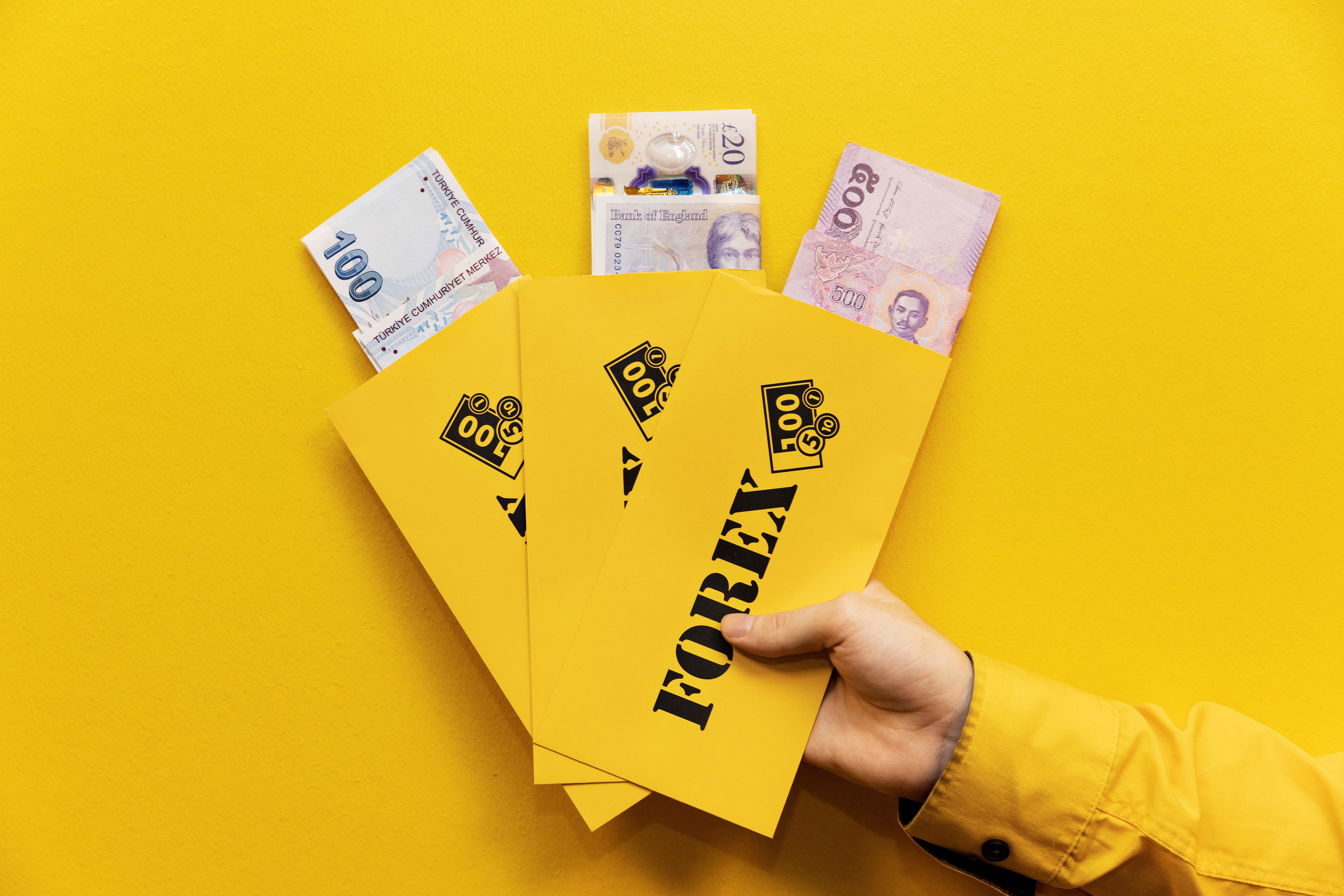 FOREX valuta konvolutter holdes av en hånd med reisevaluta synlig i dem