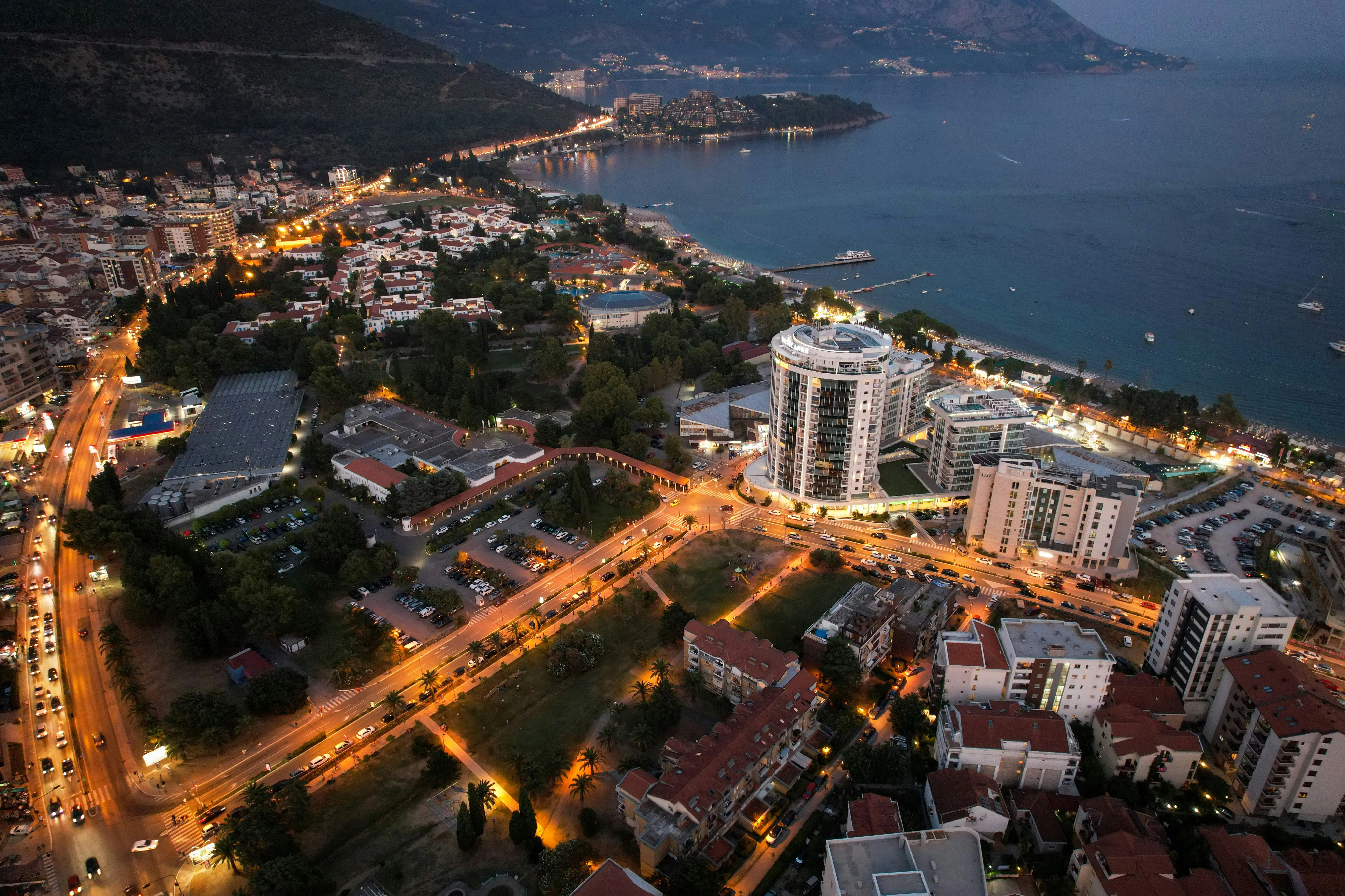 Reis til Tirana - Fugleperspektiv av Tirana i Albania om kvelden med bylys og veier som lyser opp byens bygninger