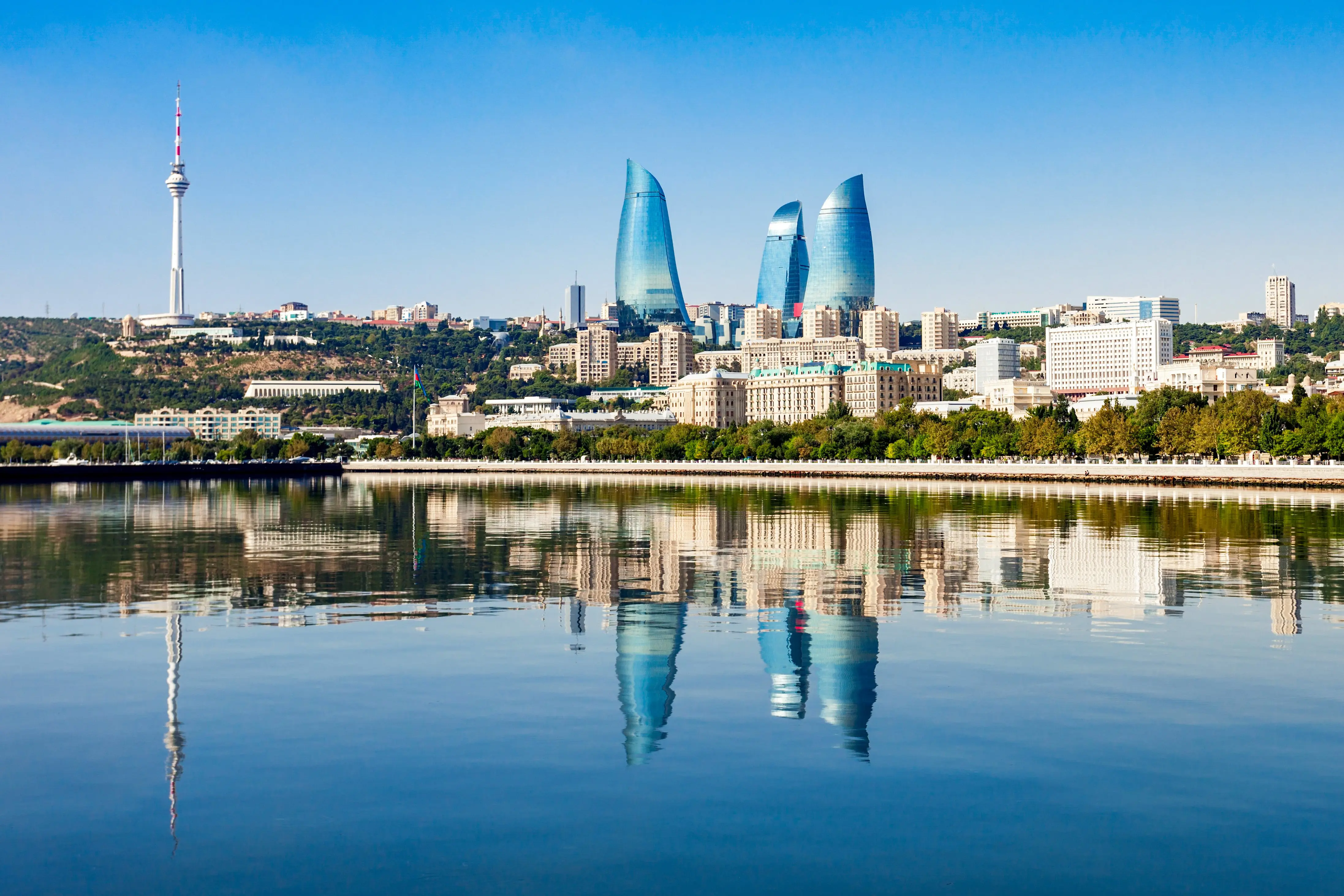 Reis til Baku - Havet møter Baku by med skyskrapere som når en blå himmel med grønne trær rundt seg