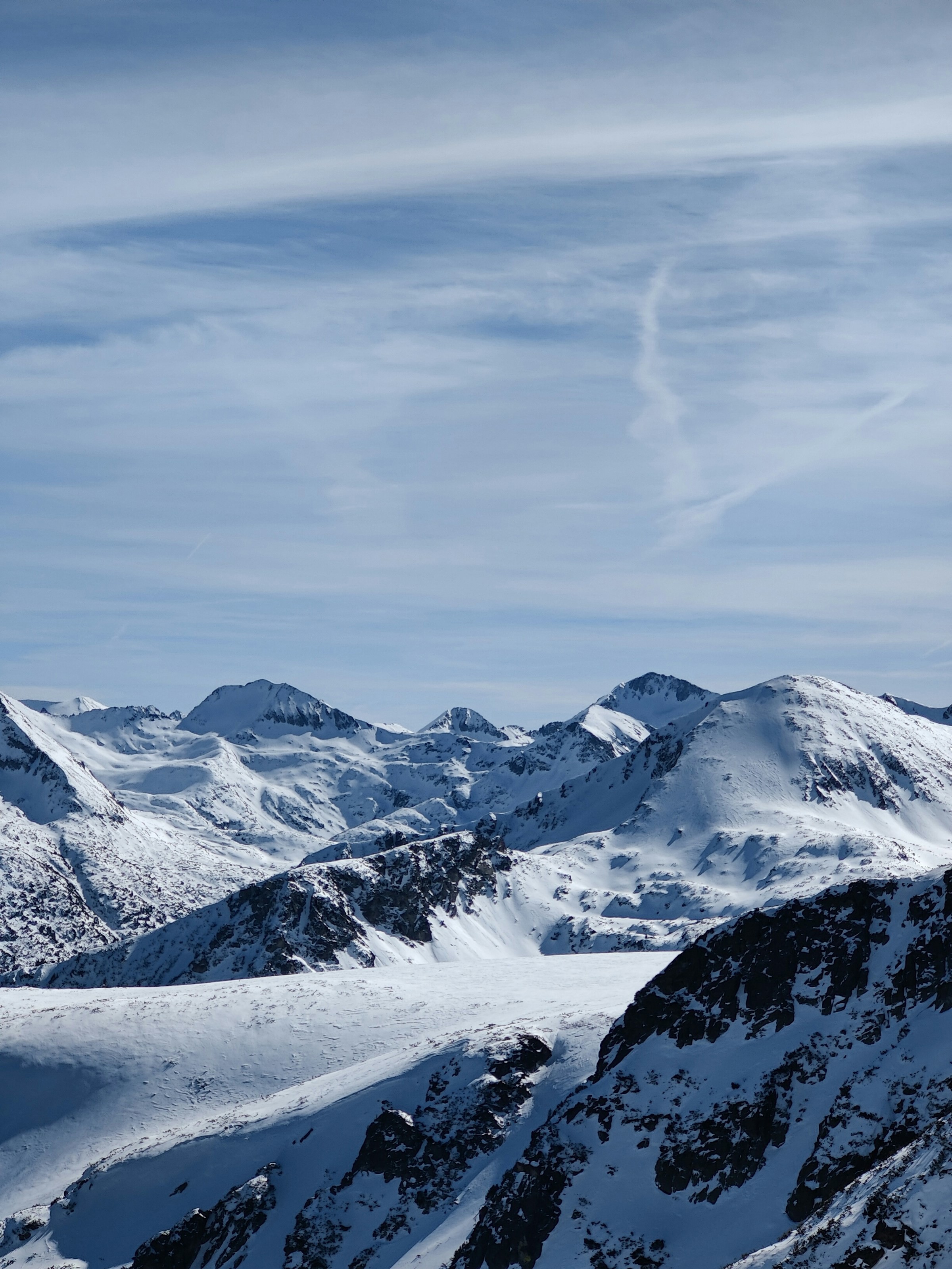 Snow-capped mountain peaks under clear skies in Bansko, Bulgaria.