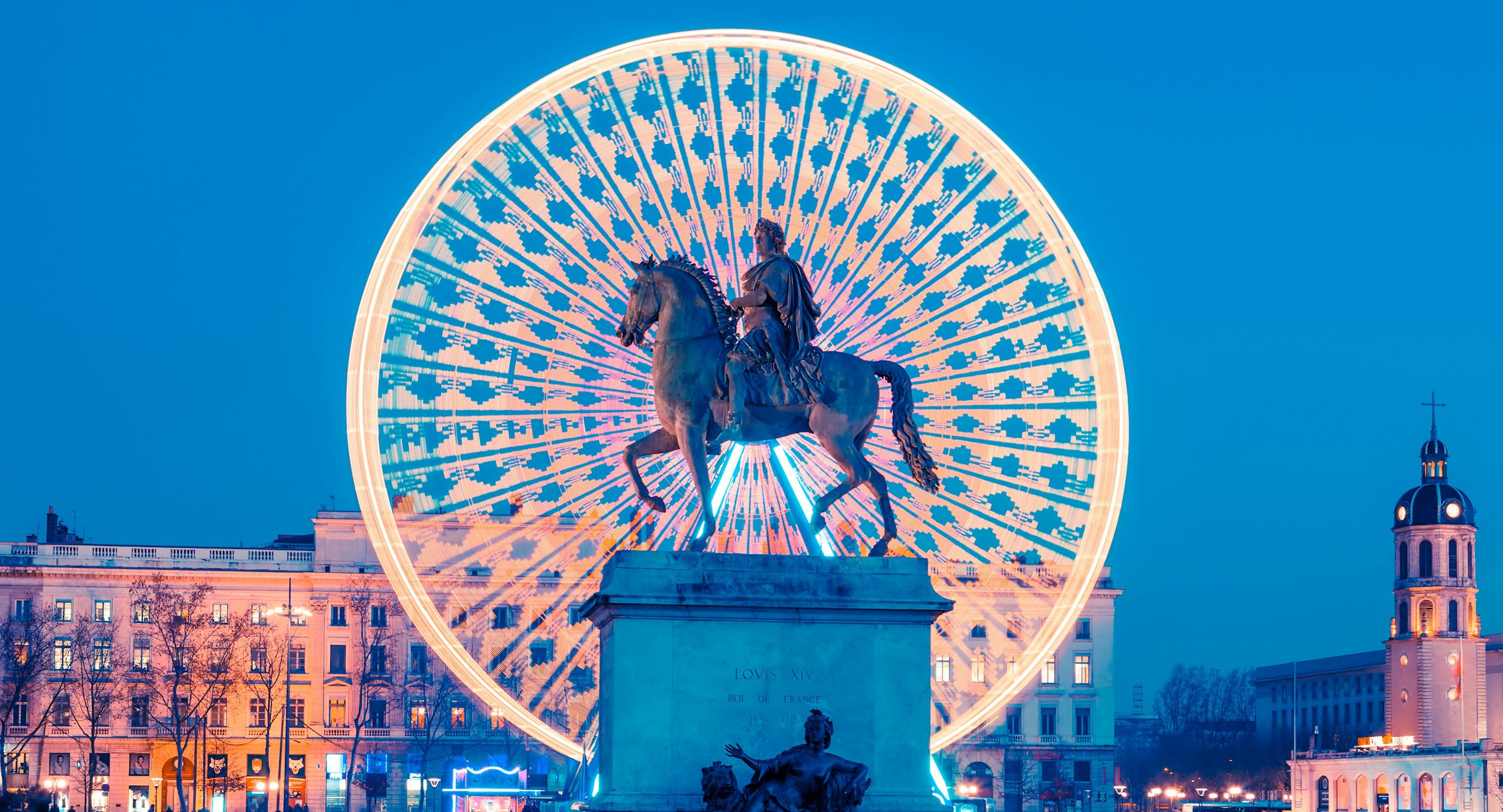 statue på et torg foran et parisisk hjul om kvelden i Lyon, Frankrike