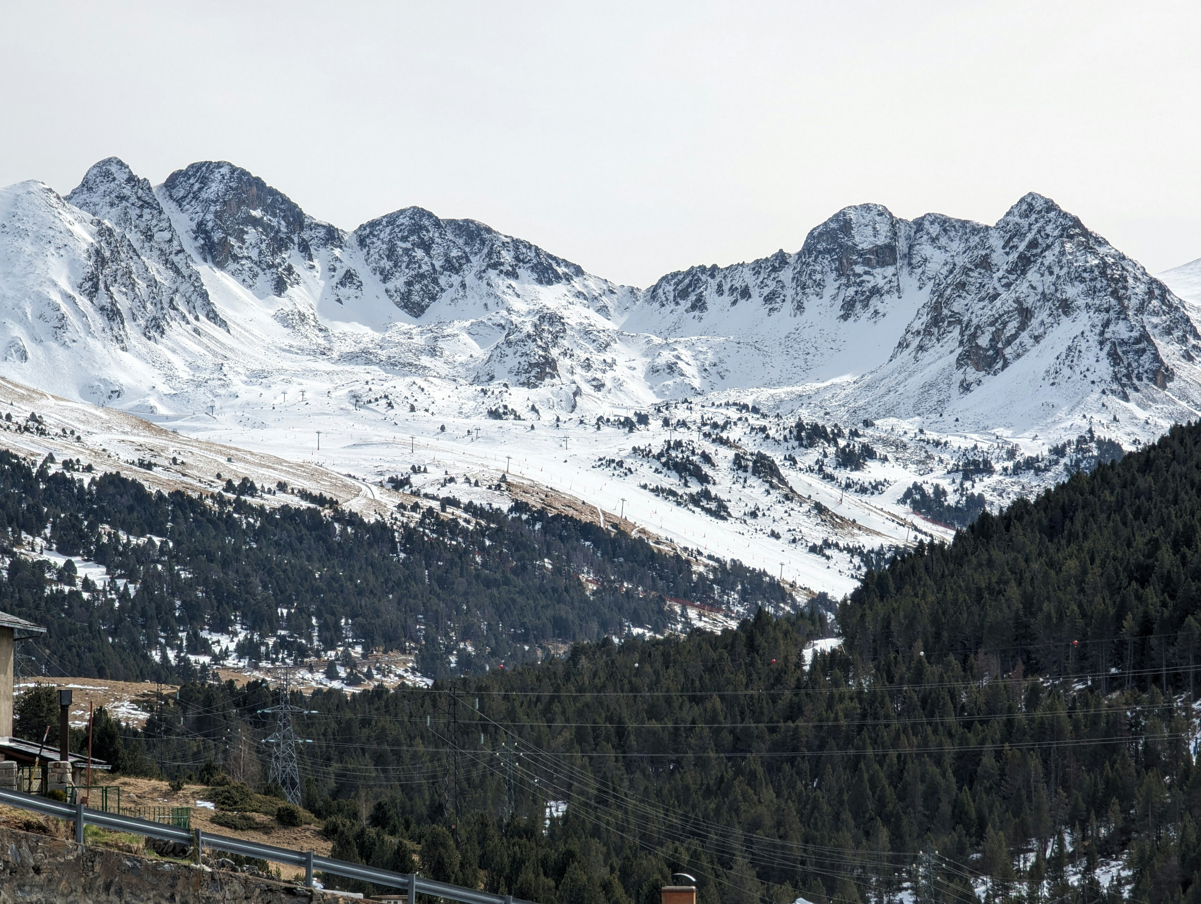 Travel to Grandvalira - View of mighty snow-capped mountains with a green valley between them in Andorra