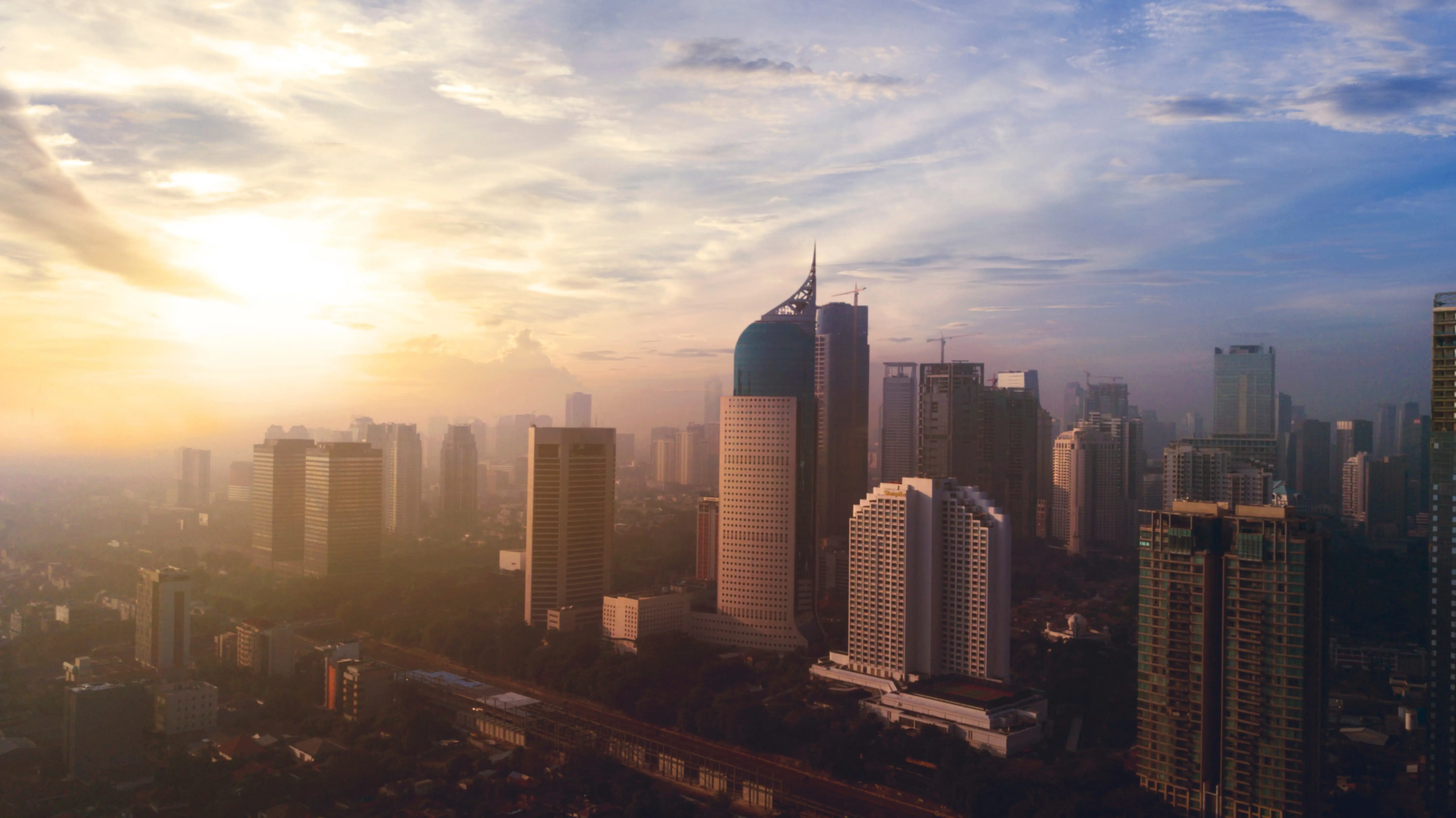 Reis til Jakarta - Soloppgang over Jakartas skyline, men skyskrapere møter en blå himmel