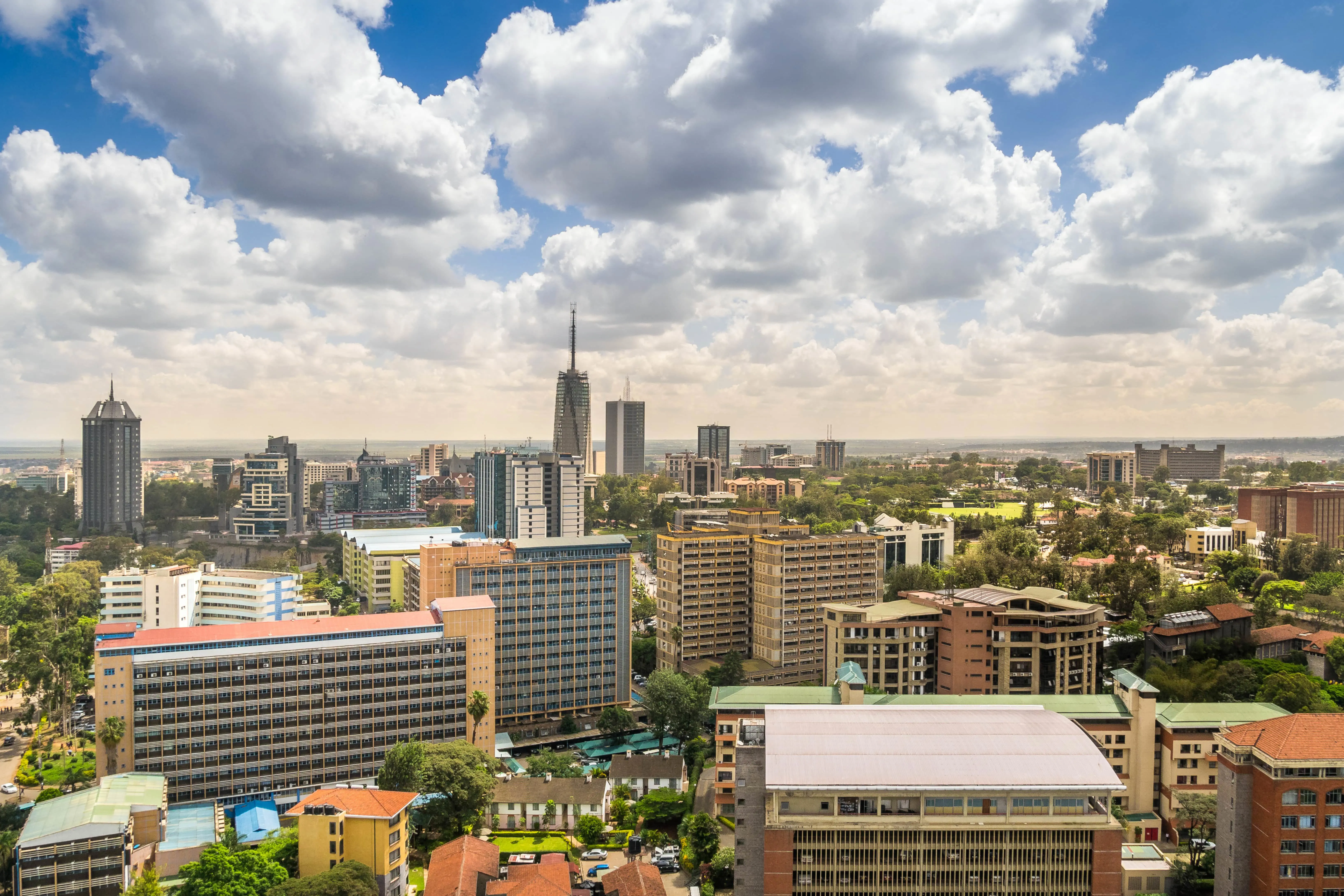 Reis til Nairobi - Utsikt over Nairobi by med flere bygninger, skyskrapere og grøntområder rundt som møter en blå himmel