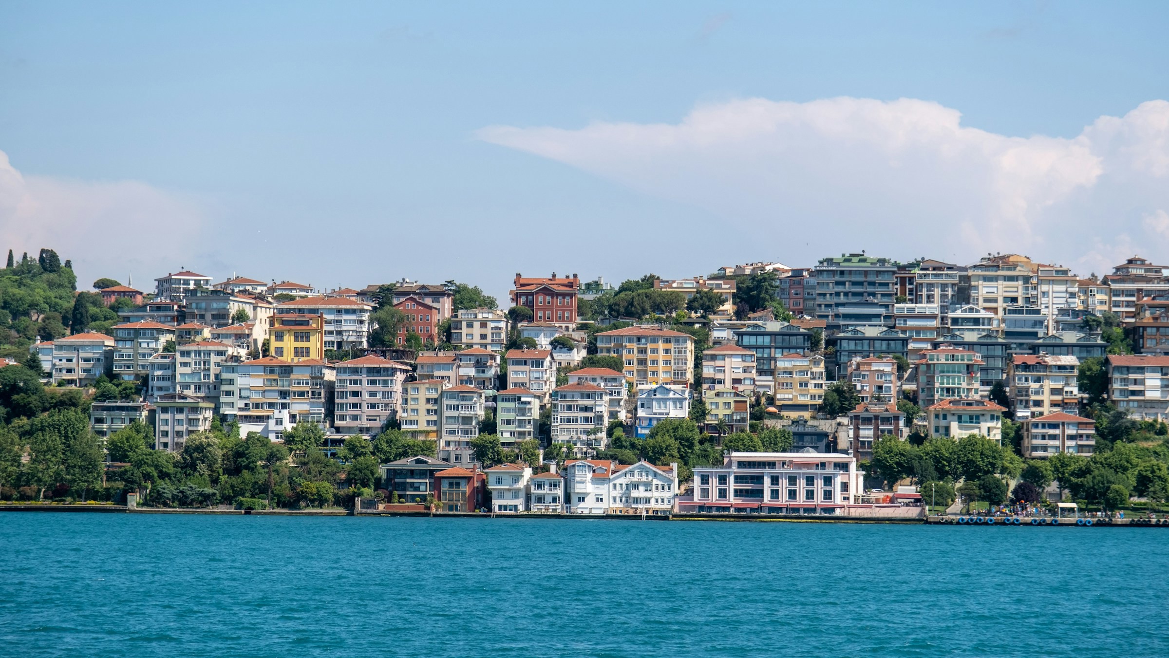 City and buildings located on a coastal edge in front of a blue lake in Kosovo