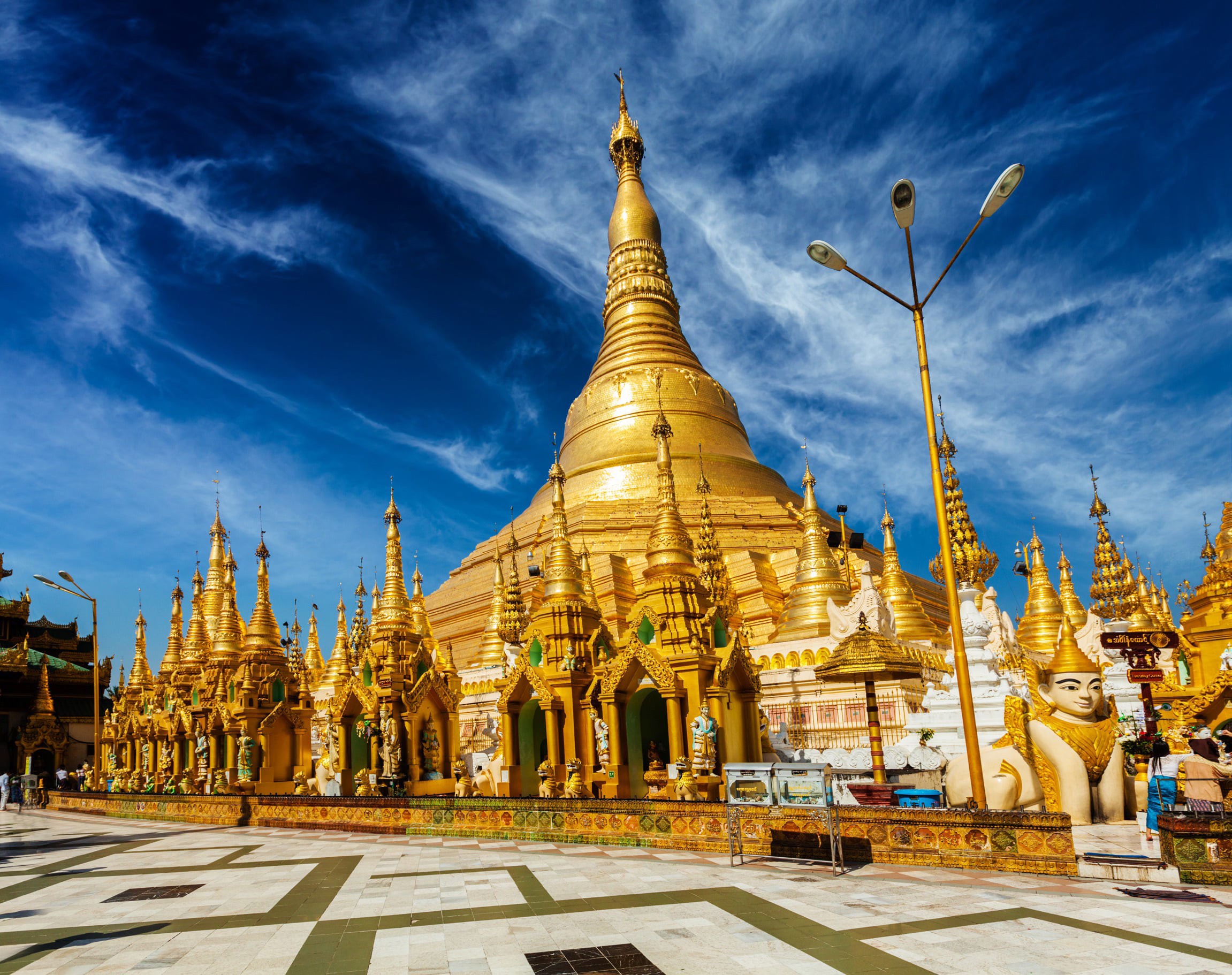 Se skrått nedenfra av berømt tempel i gull og juveler i Myanmar med vakker blå himmel i bakgrunnen