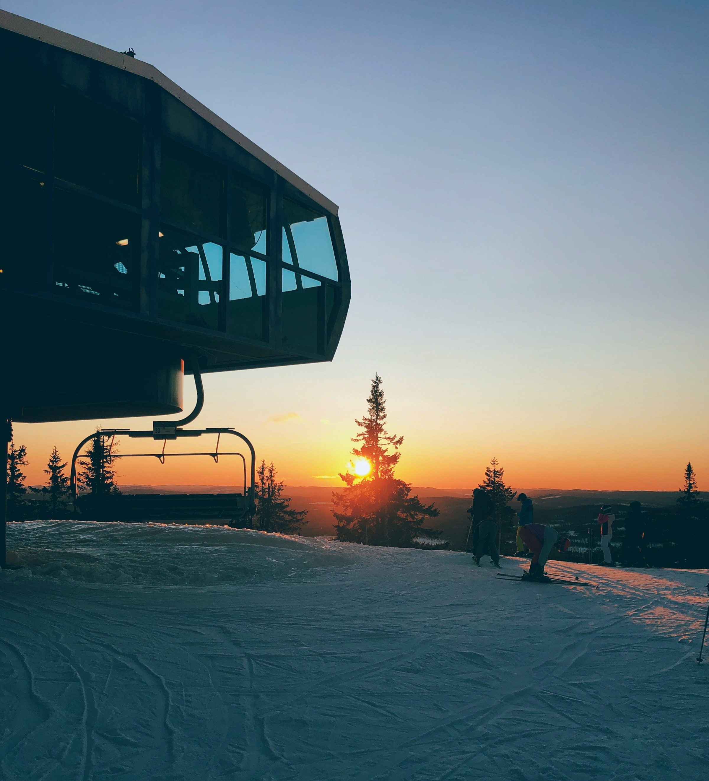 Sunset over snow-covered landscape in Trysil with ski lift and trees to the left.