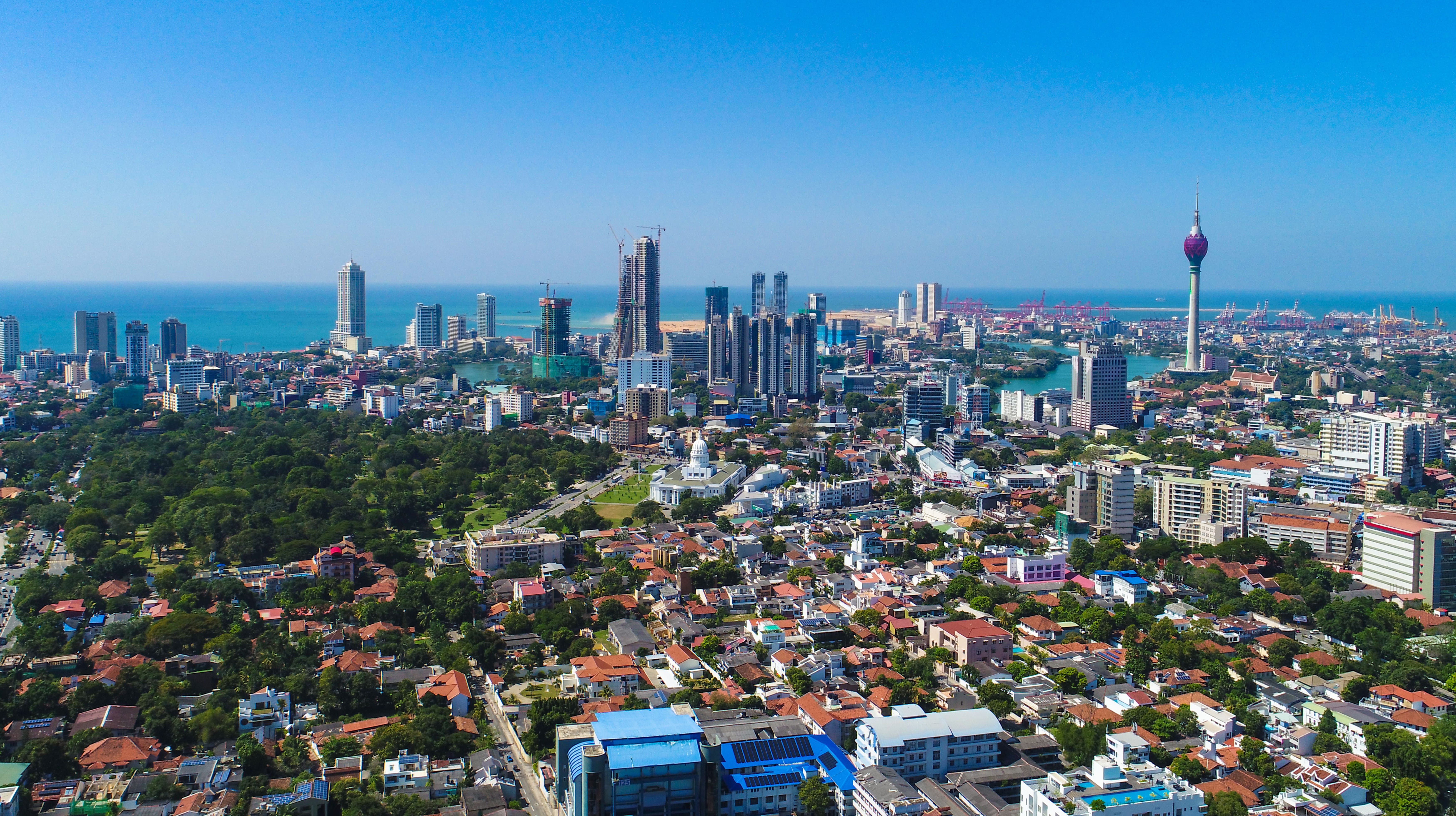 Reis til Colombo - Panoramautsikt over byen med grøntområder og bygninger som møter en kyst av blått hav og blå himmel