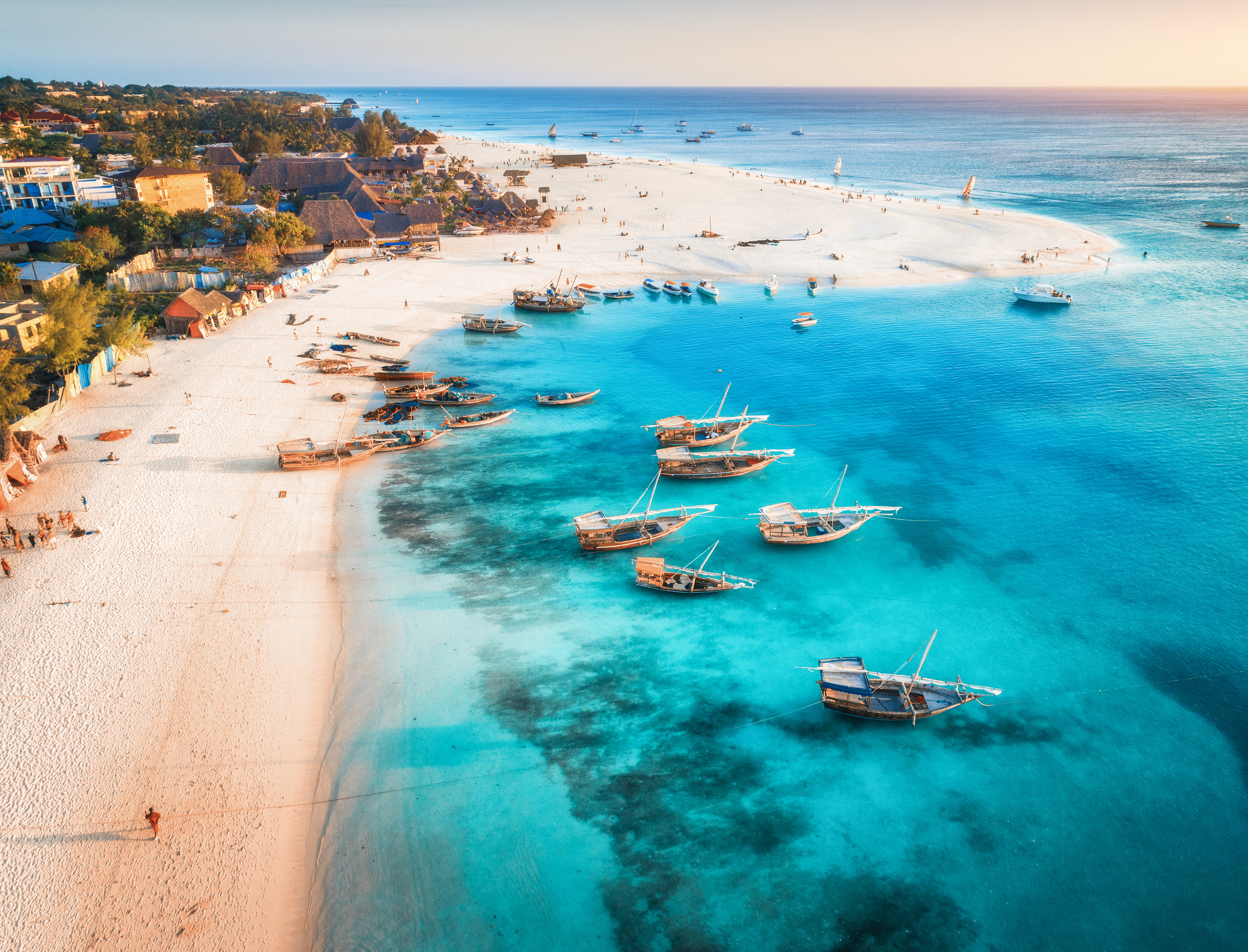Strand og krystallklart blått hav kommer inn på Zanzibar kysten