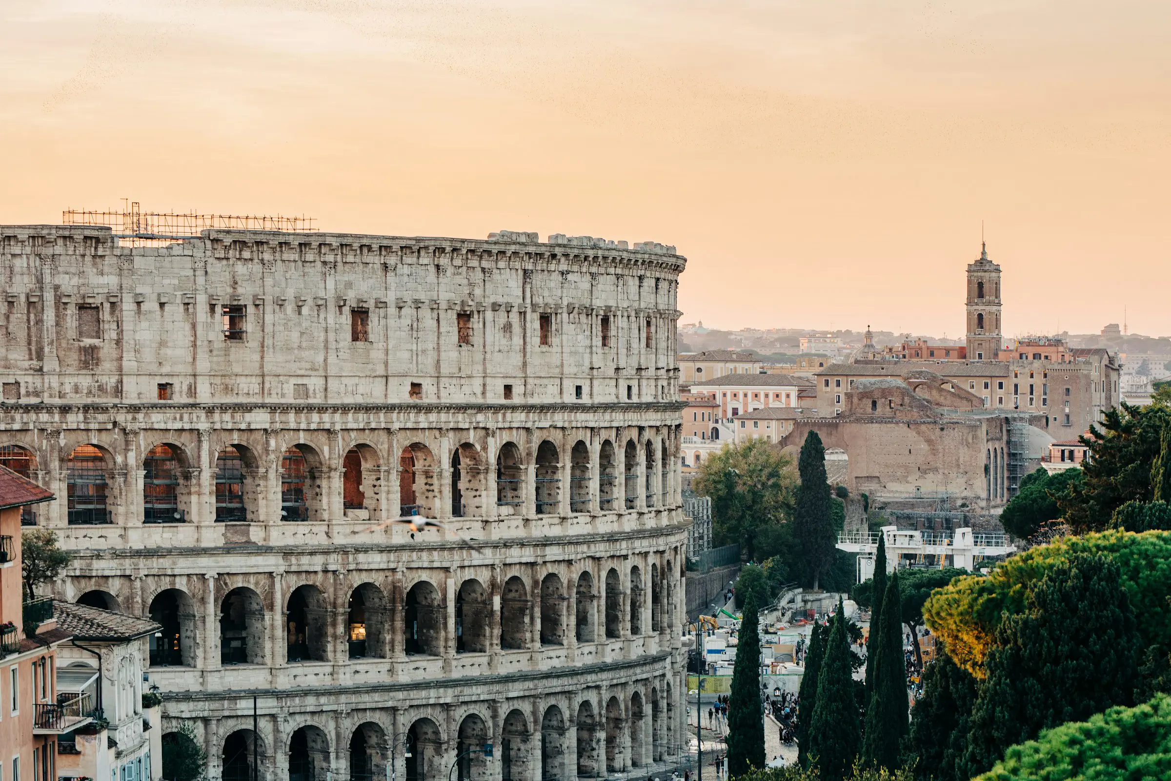 Solnedgang over Colosseum i Roma med grøntområder