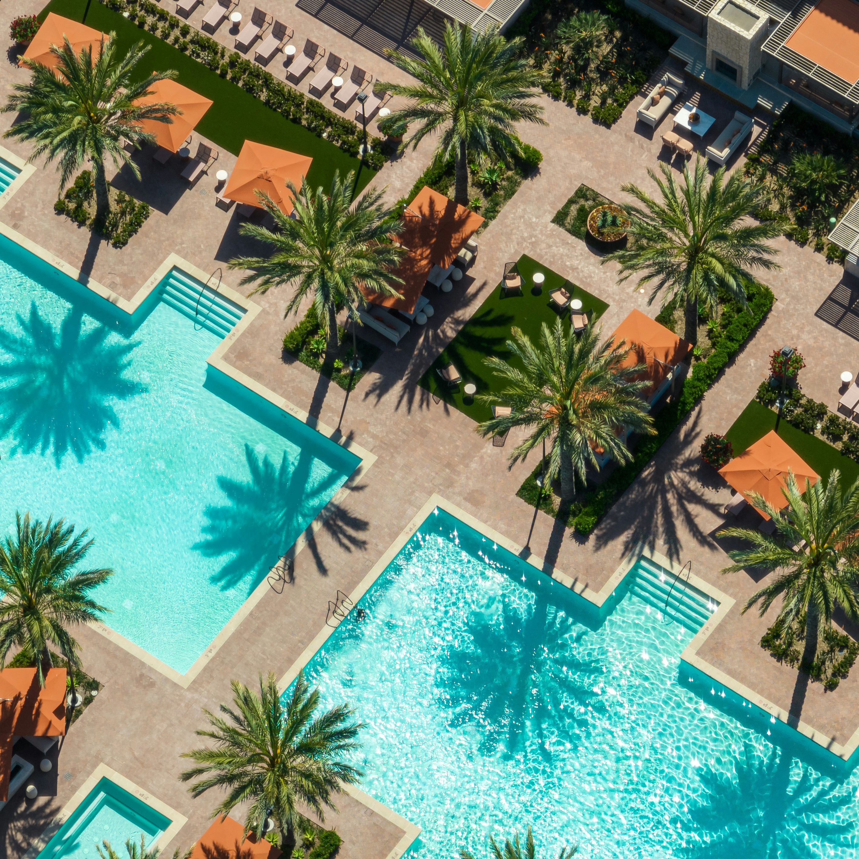 Utsikt ovenfra av et basseng med palmer rundt