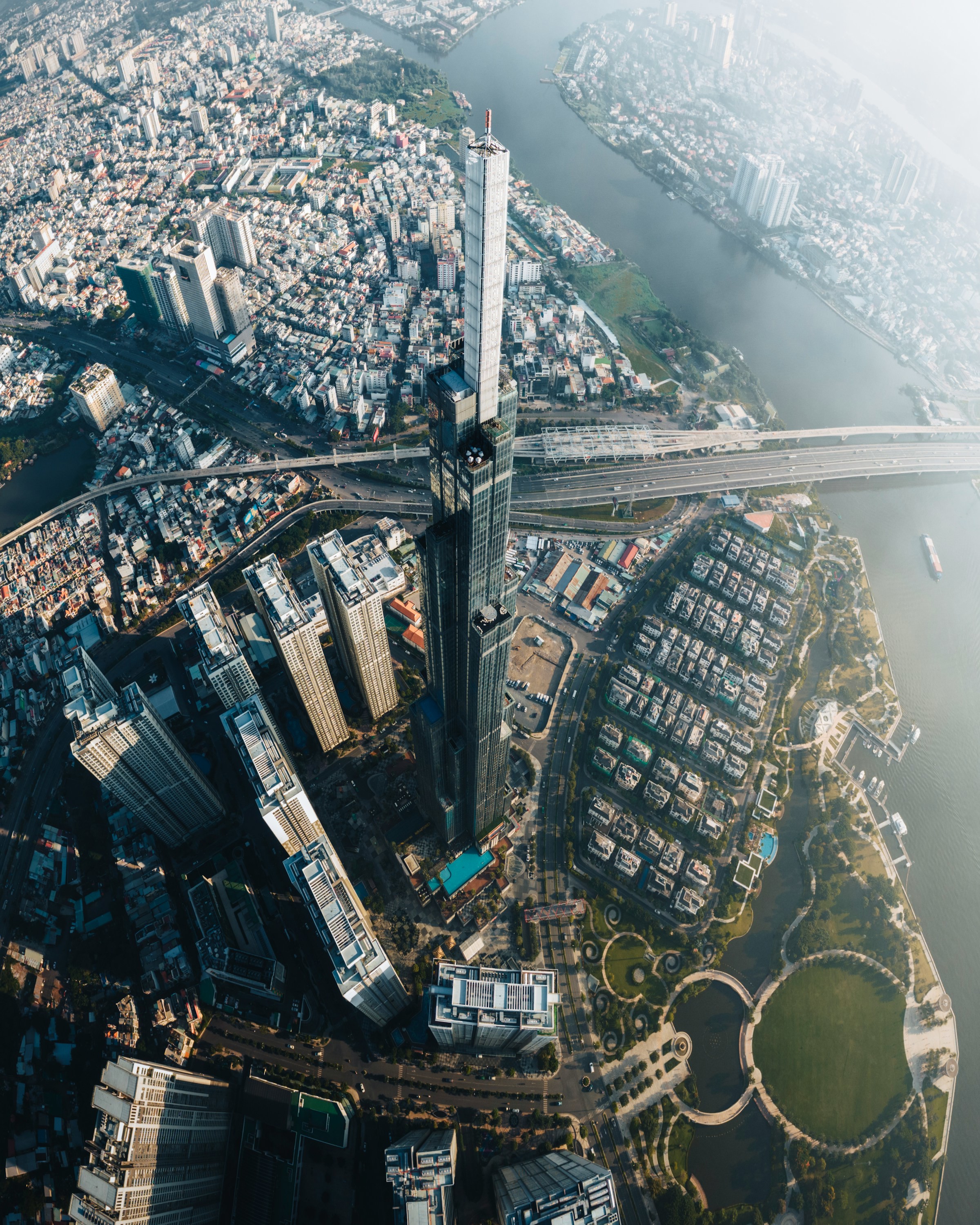 Luftfoto av Ho Chi Minh City ved vannet med høye skyskrapere og broer, i et urbant landskap.